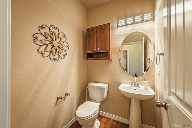 2459 Delicato Ct, Colorado Springs, CO 80921 - half bath with wood finished floors, toilet, baseboards, and a sink