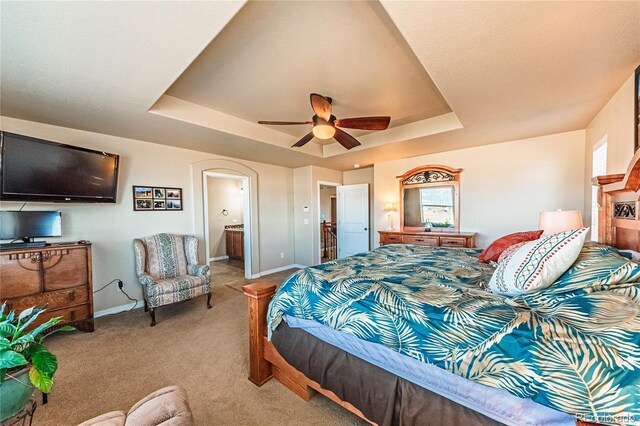 2459 Delicato Ct, Colorado Springs, CO 80921 - carpeted bedroom with a tray ceiling, baseboards, arched walkways, and ensuite bath