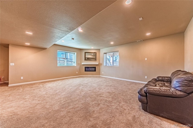 2459 Delicato Ct, Colorado Springs, CO 80921 - unfurnished living room with carpet flooring, a textured ceiling, recessed lighting, baseboards, and a glass covered fireplace