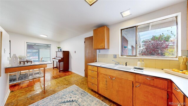 kitchen with tasteful backsplash, a wealth of natural light, sink, and light hardwood / wood-style floors