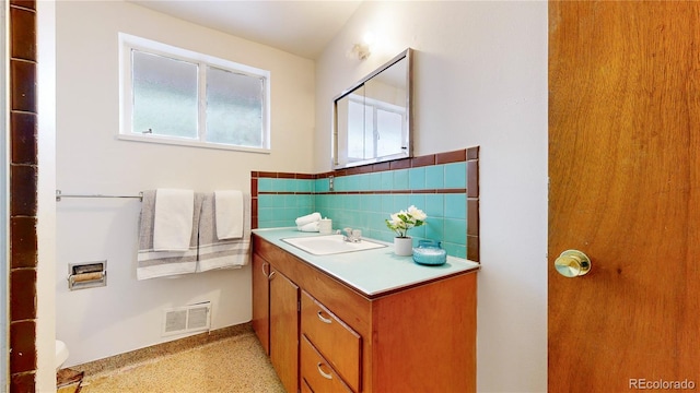 bathroom featuring vanity and tasteful backsplash