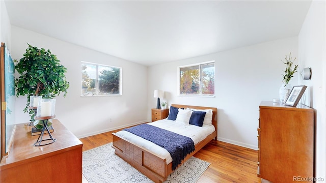 bedroom with light wood-type flooring and multiple windows