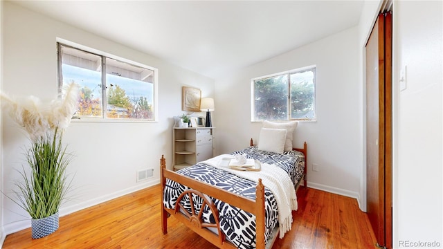 bedroom with wood-type flooring and multiple windows