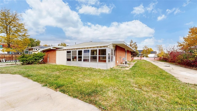 view of side of home with a yard