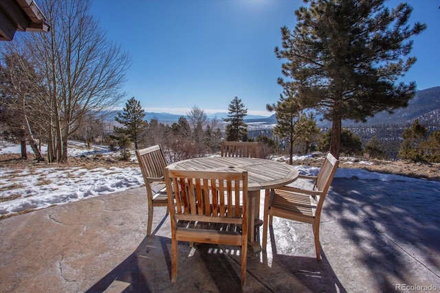 snow covered patio with a mountain view