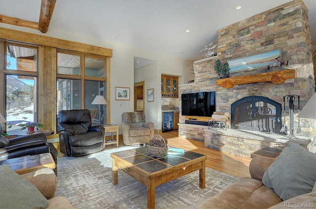 living room with beamed ceiling, hardwood / wood-style floors, and a fireplace