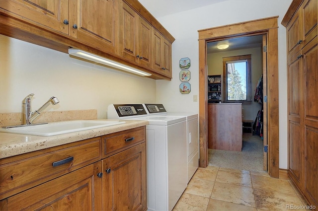 clothes washing area with cabinets, independent washer and dryer, and sink