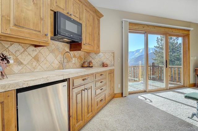 kitchen with sink, stainless steel refrigerator, backsplash, light carpet, and a mountain view