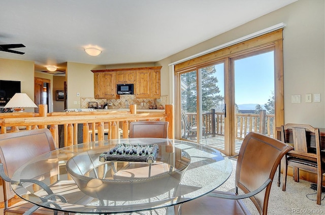 carpeted dining space with ceiling fan