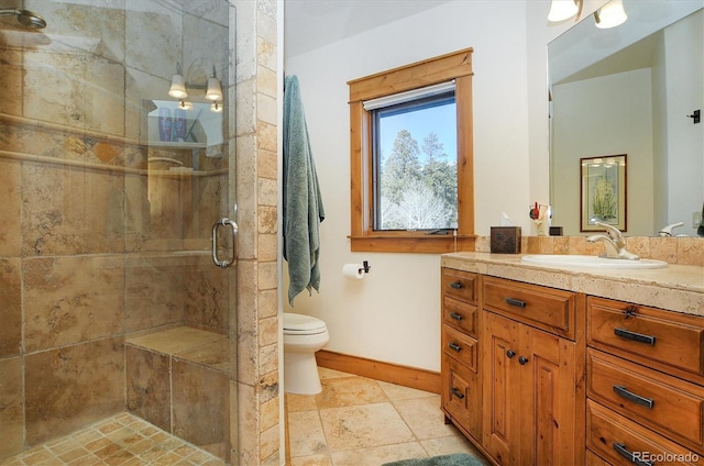 bathroom with vanity, toilet, and a shower with shower door