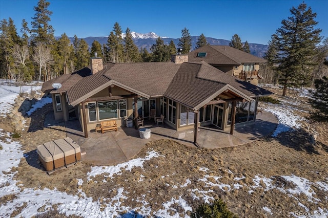 snow covered property with a patio and a mountain view