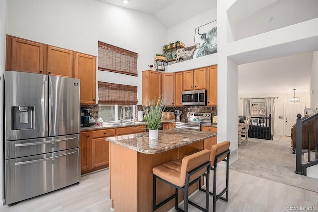 15776 E 107th Way, Commerce City, CO 80022 - kitchen with appliances with stainless steel finishes, a sink, high vaulted ceiling, a kitchen breakfast bar, and stone countertops
