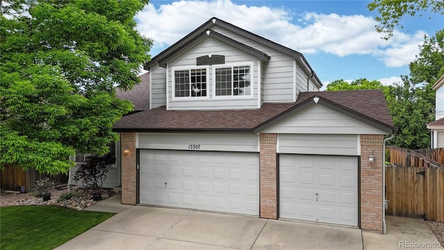 13307 Humboldt Dr, Thornton, CO 80241 - view of front of property featuring brick siding, a shingled roof, an attached garage, and driveway