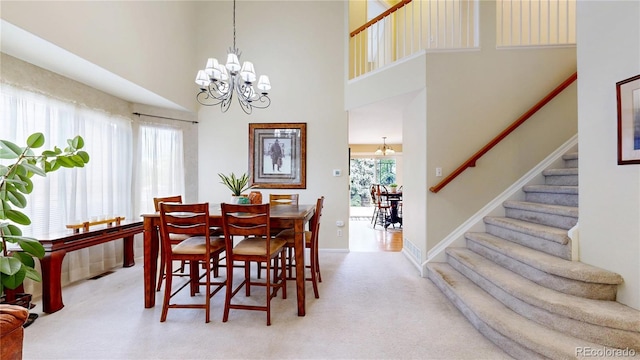 13307 Humboldt Dr, Thornton, CO 80241 - carpeted dining area with a chandelier, stairway, a high ceiling, and baseboards