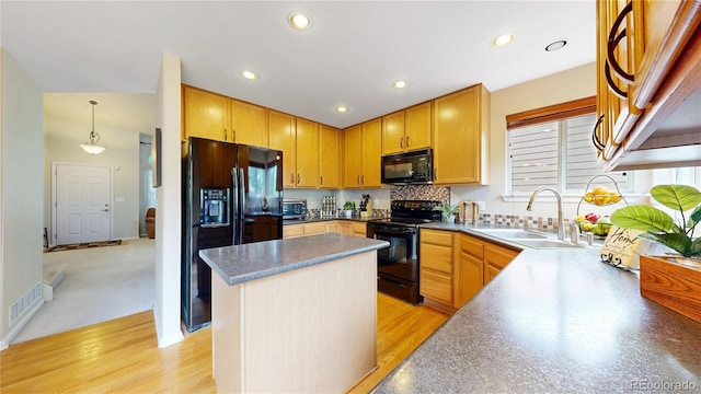 13307 Humboldt Dr, Thornton, CO 80241 - kitchen featuring a sink, black appliances, a kitchen island, recessed lighting, and decorative backsplash