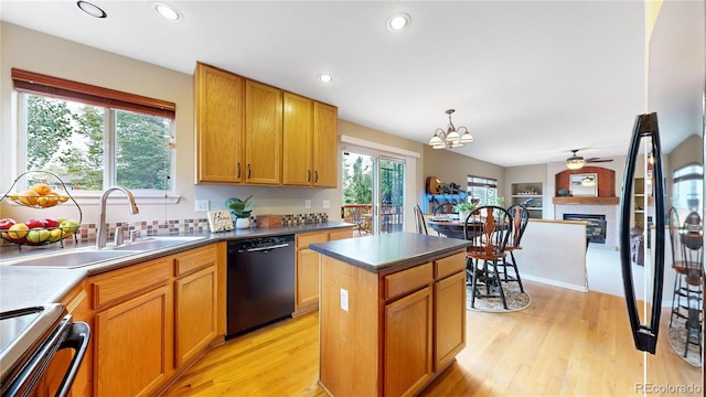 13307 Humboldt Dr, Thornton, CO 80241 - kitchen with black dishwasher, electric range, a sink, a center island, and a fireplace