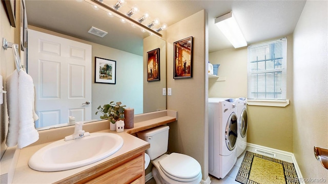 13307 Humboldt Dr, Thornton, CO 80241 - bathroom featuring washing machine and dryer, vanity, toilet, tile patterned floors, and baseboards