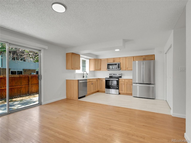 3061 W 92nd Ave Unit 14A, Westminster, CO 80031 - kitchen with stainless steel appliances, light countertops, light wood-type flooring, a textured ceiling, and light brown cabinetry