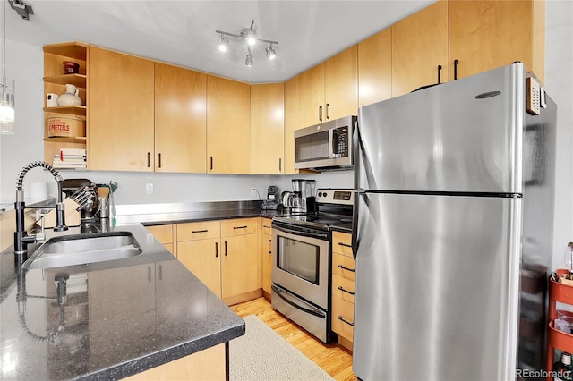 kitchen with appliances with stainless steel finishes, sink, light brown cabinetry, and light wood-type flooring