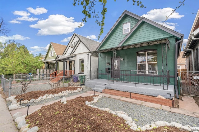 view of front of home featuring a porch, fence, and a gate