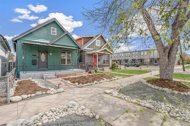 view of front of home with a porch and fence