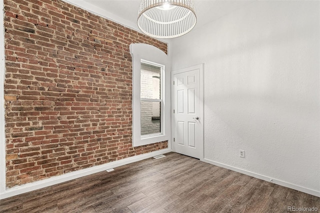 unfurnished room featuring baseboards and wood finished floors