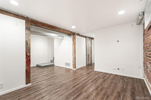 finished below grade area featuring wood finished floors, stairway, recessed lighting, and baseboards