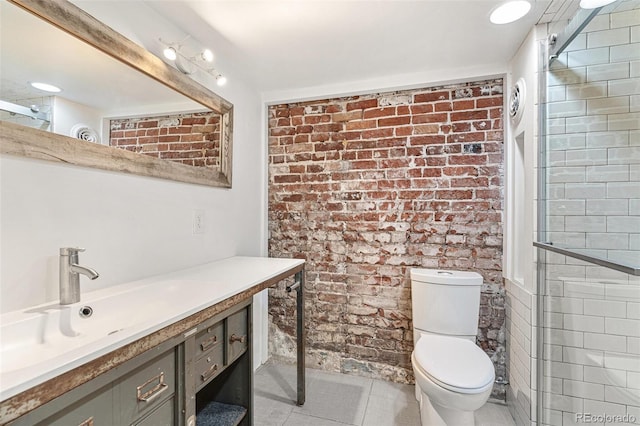 full bathroom with toilet, brick wall, tile patterned floors, and vanity