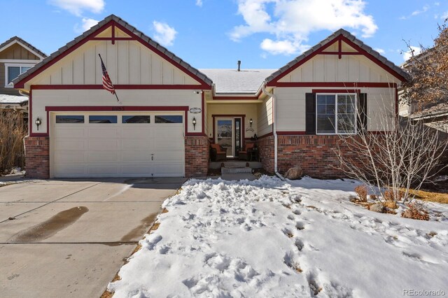 craftsman inspired home featuring board and batten siding, concrete driveway, an attached garage, and brick siding