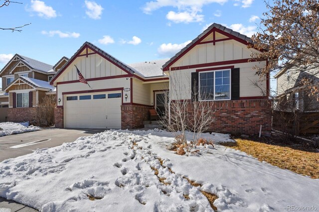 view of front of home featuring brick siding, driveway, a garage, and board and batten siding