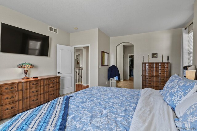 bedroom featuring visible vents and arched walkways