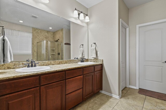 bathroom featuring double vanity, visible vents, a shower stall, and a sink