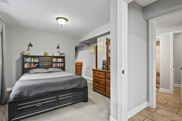 bedroom with baseboards and a textured ceiling