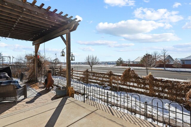 snow covered patio with a pergola