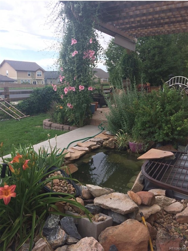 view of yard featuring a small pond and a pergola