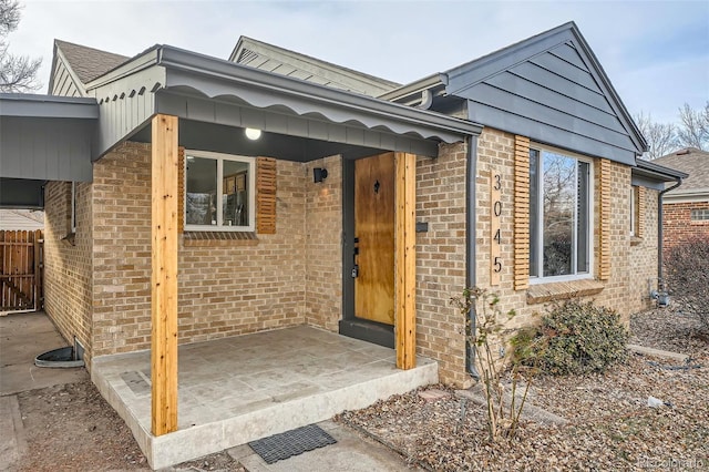 exterior space with a patio area, fence, and brick siding