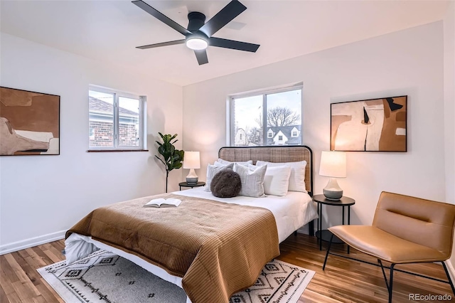 bedroom featuring a ceiling fan, baseboards, and wood finished floors