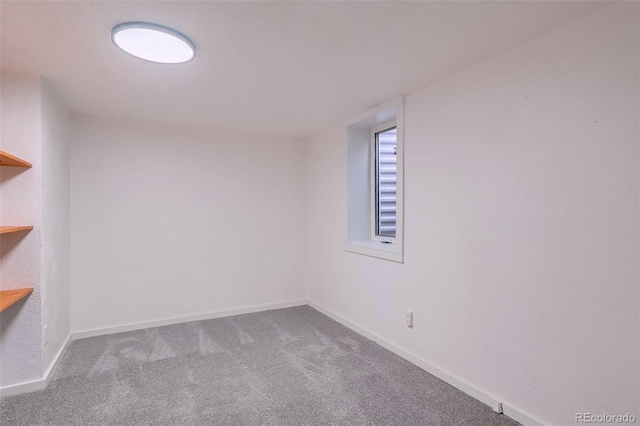 carpeted empty room featuring baseboards