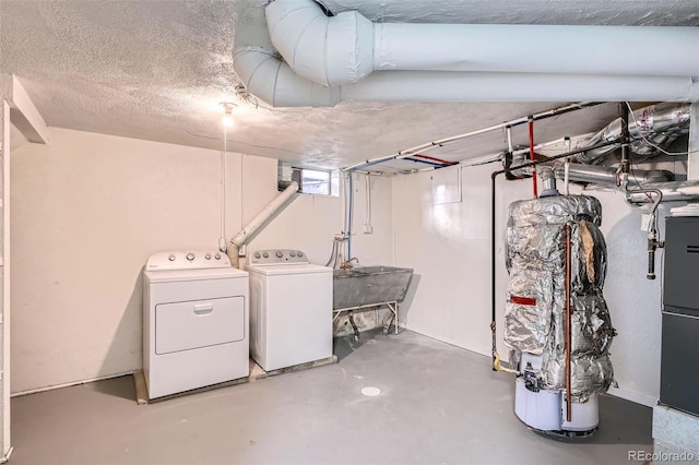 below grade area with a sink, a textured ceiling, and washing machine and clothes dryer