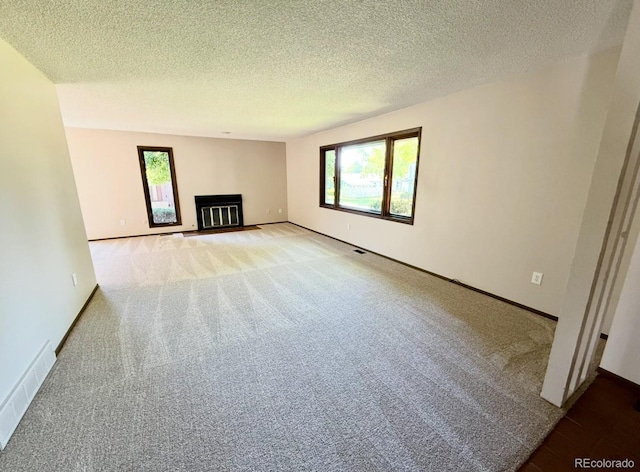 53 Douglas Dr S, Broomfield, CO 80020 - unfurnished living room with carpet, plenty of natural light, a textured ceiling, and baseboards