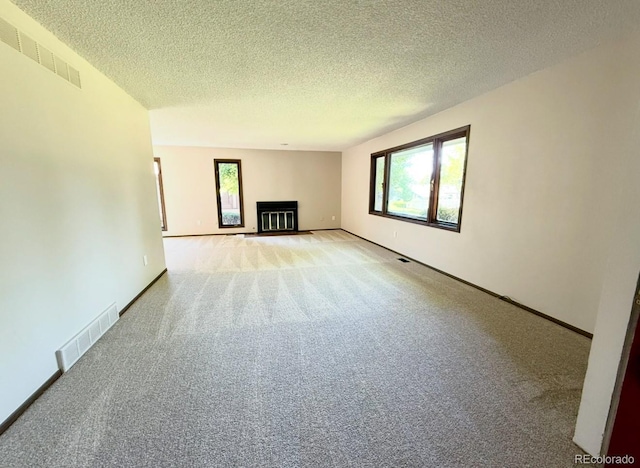 53 Douglas Dr S, Broomfield, CO 80020 - unfurnished living room with light carpet, a glass covered fireplace, a textured ceiling, and baseboards