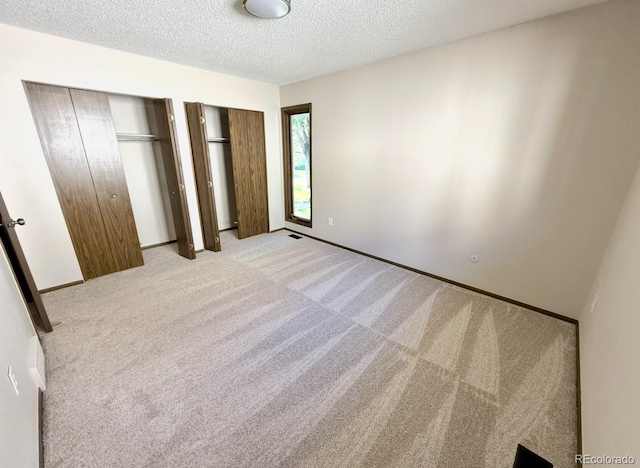 53 Douglas Dr S, Broomfield, CO 80020 - unfurnished bedroom with two closets, light carpet, a textured ceiling, and baseboards