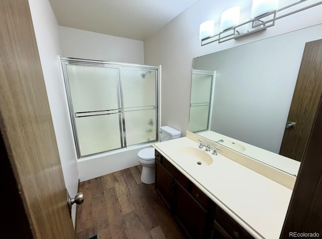 53 Douglas Dr S, Broomfield, CO 80020 - bathroom with toilet, vanity, wood finished floors, and combined bath / shower with glass door