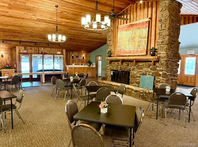 53 Douglas Dr S, Broomfield, CO 80020 - carpeted dining space featuring wood ceiling, a chandelier, wooden walls, high vaulted ceiling, and a stone fireplace
