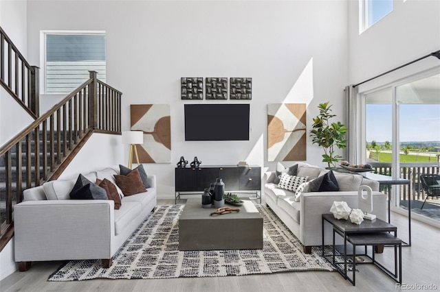 13326 Blue Amber Ct, Parker, CO 80134 - living area featuring stairs, wood finished floors, and a towering ceiling