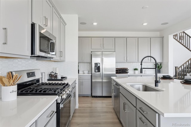 13326 Blue Amber Ct, Parker, CO 80134 - kitchen with stainless steel appliances, gray cabinets, light countertops, light wood-style flooring, and recessed lighting