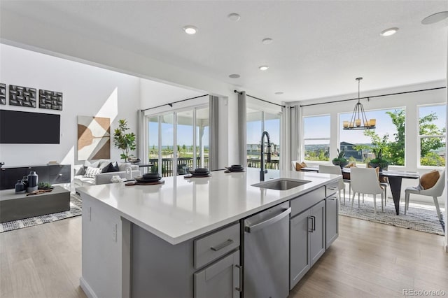 13326 Blue Amber Ct, Parker, CO 80134 - kitchen with dishwasher, gray cabinetry, light countertops, light wood finished floors, and pendant lighting