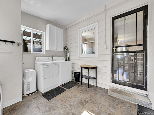 clothes washing area with cabinets and washing machine and dryer