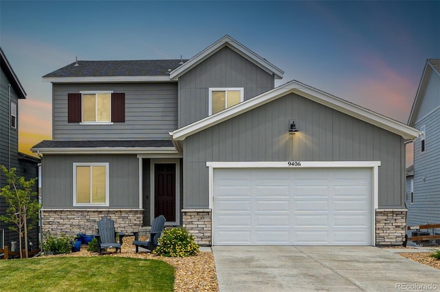 9406 Bross St, Arvada, CO 80007 - view of front of property featuring stone siding, driveway, a shingled roof, a yard, and a garage