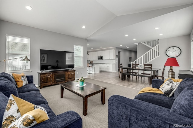 9406 Bross St, Arvada, CO 80007 - living room with vaulted ceiling, stairway, recessed lighting, and light carpet